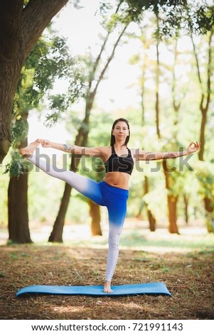 Summer yoga practice is one with nature. large coniferous forest in the background.