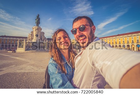 handsome couple tourist take selfie photo with panorama of Praca do Comercio and Statue of King Jose I in Lisbon, Portugal