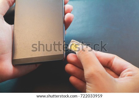 Employees are putting nano SIM cards in the store for customers to buy,
Man's hand. Royalty-Free Stock Photo #722033959