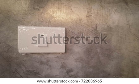 Light switches wrapped in cement walls and light in the morning.
