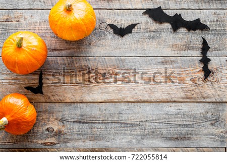 Halloween background. Pumpkins and paper bats on wooden background top view copyspace