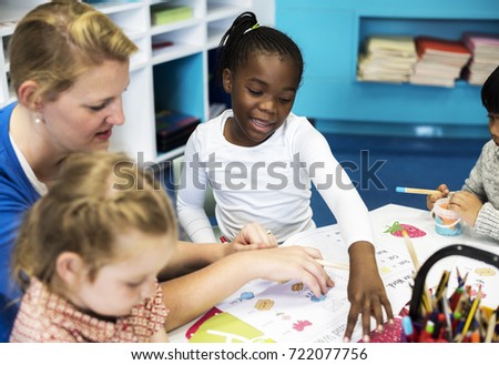Group of diverse Kids coloring workbook in class