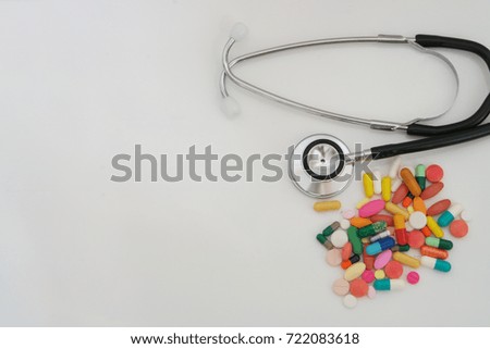 Drugs and stethoscope on white table with room for text, healthcare concept