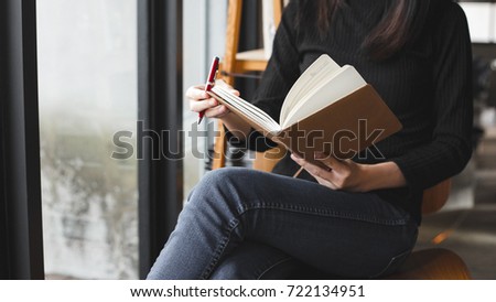 woman sit down to writing a notebook on her legs