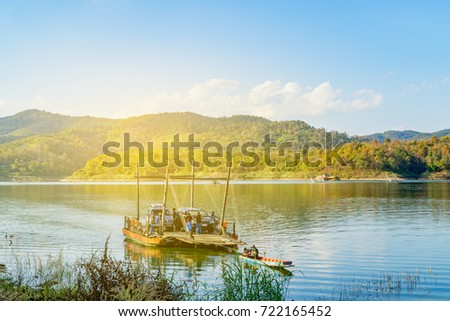 Wooden raft ferry  was transfering cars and passenger  cross Sirikit reservoir  between Nan and Uttaradit  province .Located in The fishing village " Pak Nai " in Nan province , Northern of Thailand