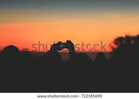 Silhouette hand holding a camera Sunset.professional photographer Sunset.selective focus.