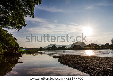 The river reflects the sun and sky pictures as background.