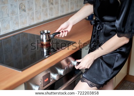 A picture of a young wife preparing coffee in the kitchen in the morning