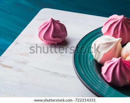 Pastel color pink and white meringue on green background
