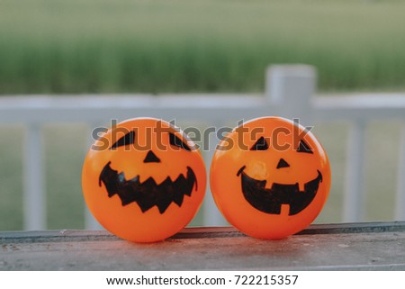 Self Made hand drown Smiley face Halloween Spooky balls in orange on the window with field background