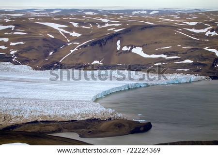 Breathtaking landscapes forced to love Arctic. So typical Novaya Zemlya, Northern isl. Plateau with whimsically scattered snowfields, sliding into Kara sea outlet glacier, wilderness. Helicopter view
