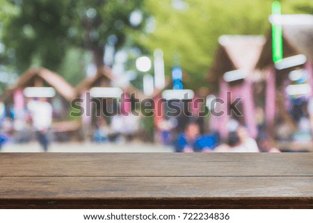 Wood table top and blurred garden restaurant exterior background - can used for display or montage your products.