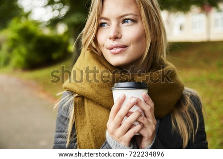 Blue eyed blond woman with coffee in park, looking away Royalty-Free Stock Photo #722234896