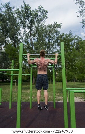 Strong yooung man having workout in the park