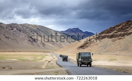 Convoy of military trucks is moving through Changthang plateau in Ladakh region of Kashmir, India. Royalty-Free Stock Photo #722263018