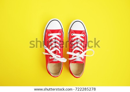 New red sneakers on yellow background with copy space. Royalty-Free Stock Photo #722285278