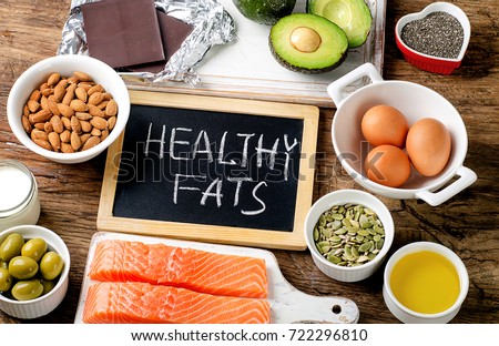 Selection of healthy fat sources on wooden background. Top view