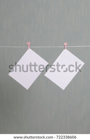 Photographic prints hang after developing on a cord and dry. There is a place to insert your content. Attached to the cord with clothes pegs in different positions. On a gray-green background.