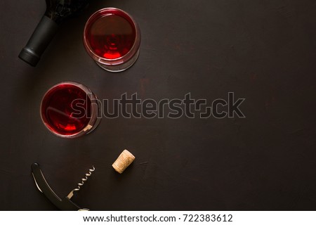 Two wineglasses with red wine and lying bottle on brown wooden desk. Top view.  Royalty-Free Stock Photo #722383612