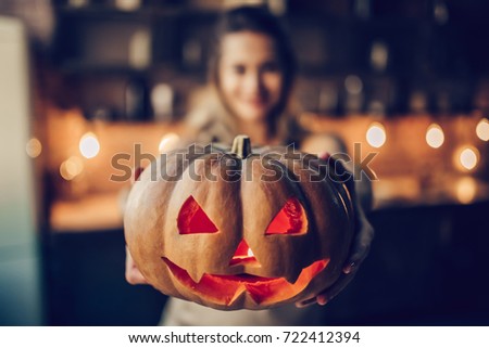 Happy Halloween! Attractive young woman is preparing to Halloween on kitchen. Beautiful woman with pumpkins.