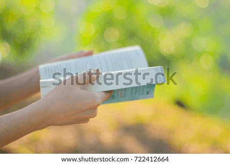 Close up woman reading book in the park.