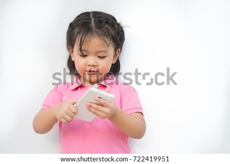 Cute little asian girl using smart phone.Child development and technology .