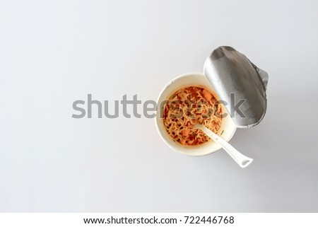 closeup mama or noodle in cup and tomyam soup on white table with sofe-focus and over light in the background