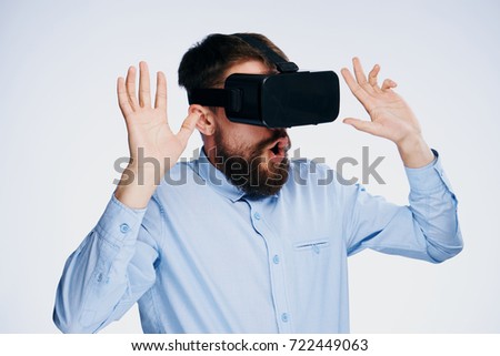  surprised man with a beard in 3d glasses on a light background                              