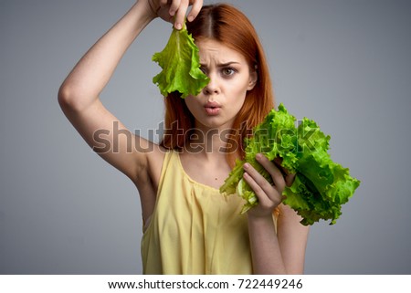 diet, lettuce, young woman grows thin on a gray background, eating restrictions                               