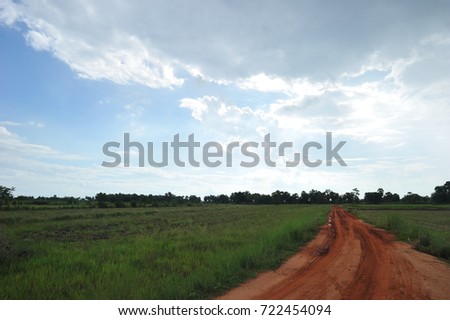 Gravel road grass green and blue sky