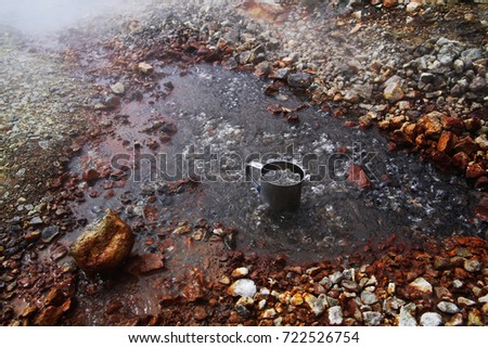 Boiling water from a hot spring. Geyser in Iceland. Fumaroles in the caldera of the volcano. Texture of stones and water, background.