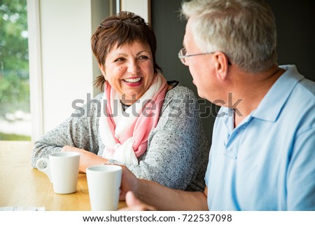 Senior couple in love sitting in cafe, drinking coffee, talking, laughing and having fun. Happy people in retirement concept. Royalty-Free Stock Photo #722537098