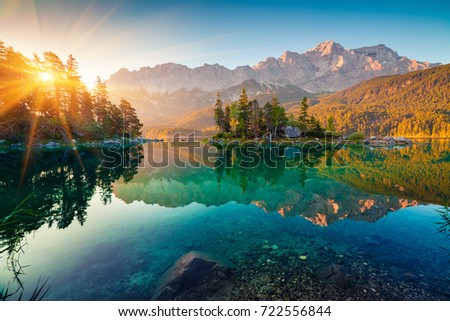 Impressive summer sunrise on Eibsee lake with Zugspitze mountain range. Sunny outdoor scene in German Alps, Bavaria, Germany, Europe. Beauty of nature concept background.
