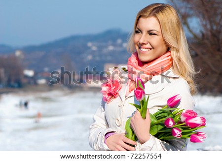 Beautiful young blonde woman with pink tulips