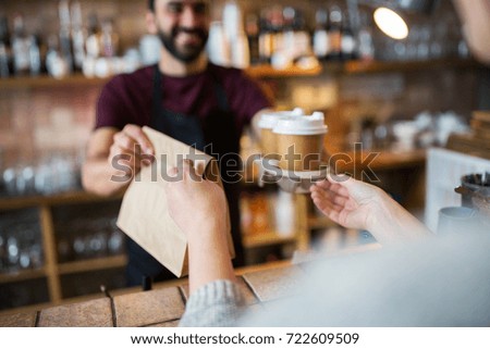 small business, people and service concept - man or bartender serving customer at coffee shop Royalty-Free Stock Photo #722609509