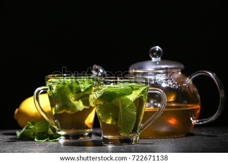 Cups with tasty mint tea on table