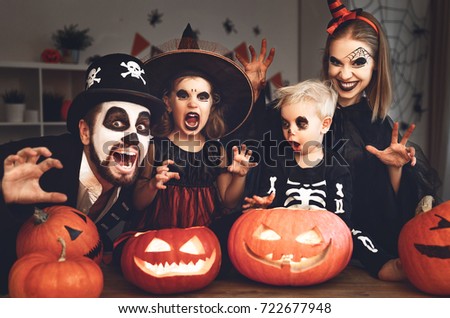 happy family mother father and children in costumes and makeup on a celebration of Halloween
