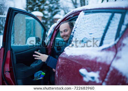 a man in a snow-covered car, a driver in the winter after a snowfall
