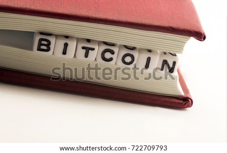 The word bitcoin between the pages of the notebook