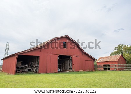 Beautiful red barn in a green, grassy field.