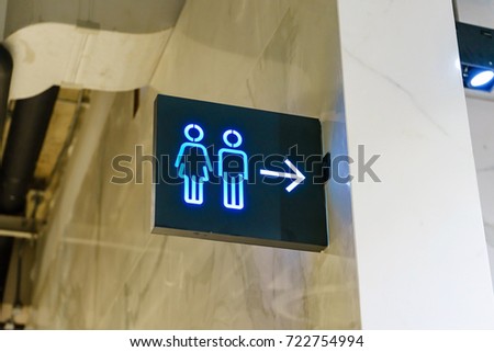 Toilets icon. Light box of public restroom sign on the top of the entrance, Interior of shopping mall.