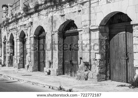 Flaked gates in historic part of Valletta. Entrance to an abandoned house on the island of Malta. Black and white picture