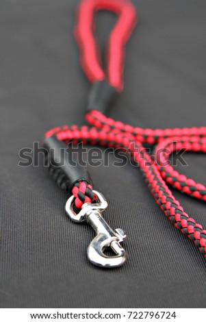 Small Pet leash hook red color For wearing with a pet collar on isolated black background. To take pets to walk or train.
