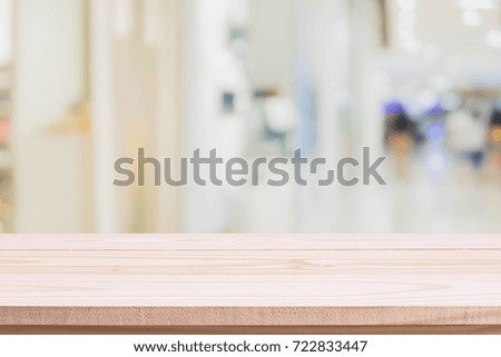 Wood table top on blurred with bokeh shopping mall background - can be used for display or montage your products.