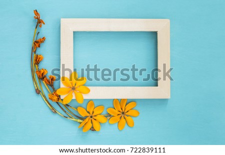 Wooden frame decorate with yellow flower on blue background