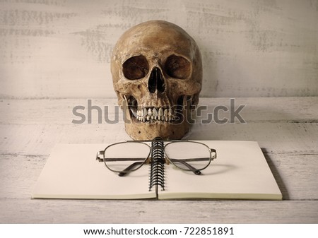 still life skull with glasses on wooden table.(selective focus)