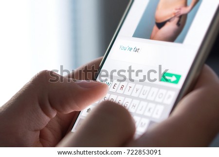 Body shame, cyber bullying and bad behavior online concept. Internet troll sending mean comment to picture on an imaginary social media website with smartphone. 