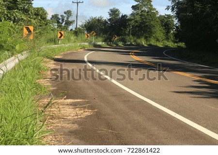 Three turn road sign on curveed road