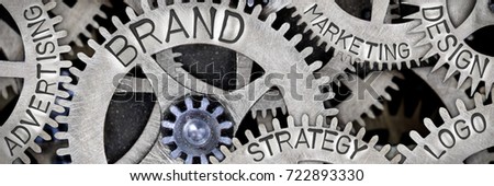 Macro photo of tooth wheel mechanism with BRAND, LOGO, DESIGN, STRATEGY, ADVERTISING and MARKETING concept words Royalty-Free Stock Photo #722893330