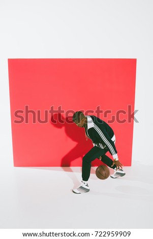 high angle view of stylish african american man playing with basketball ball in studio